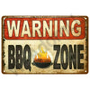 A vintage metal sign with the text WARNING BBQ ZONE in bold lettering on an orange background.