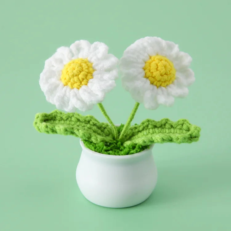 Hand woven white and yellow daisy flowers in a green pot