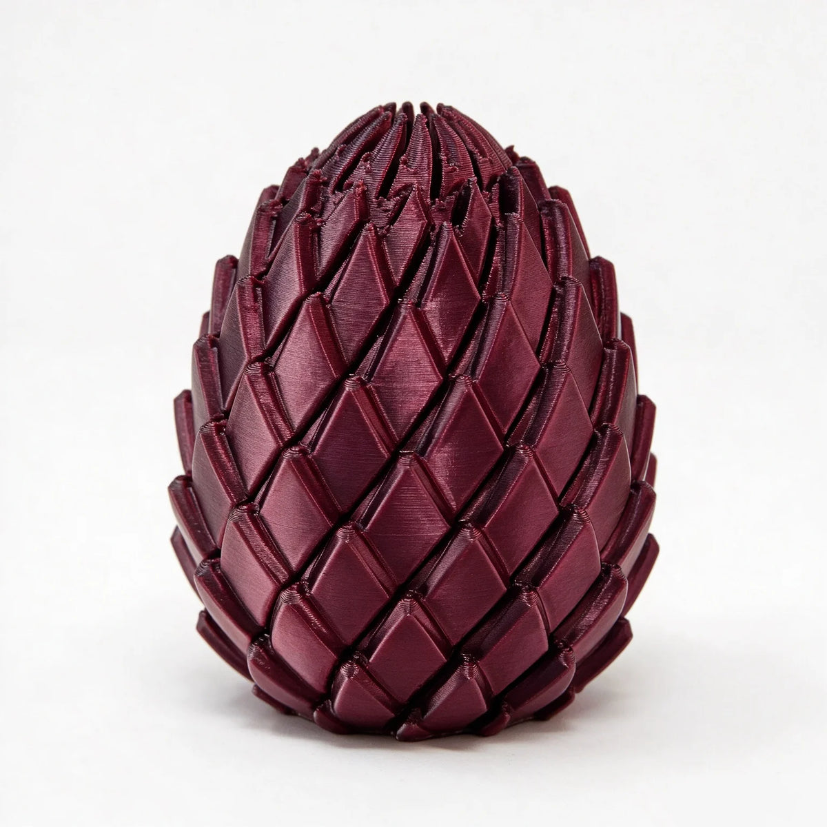 A dark burgundy, textured dragon egg stress relief toy with a pyramidal shape.