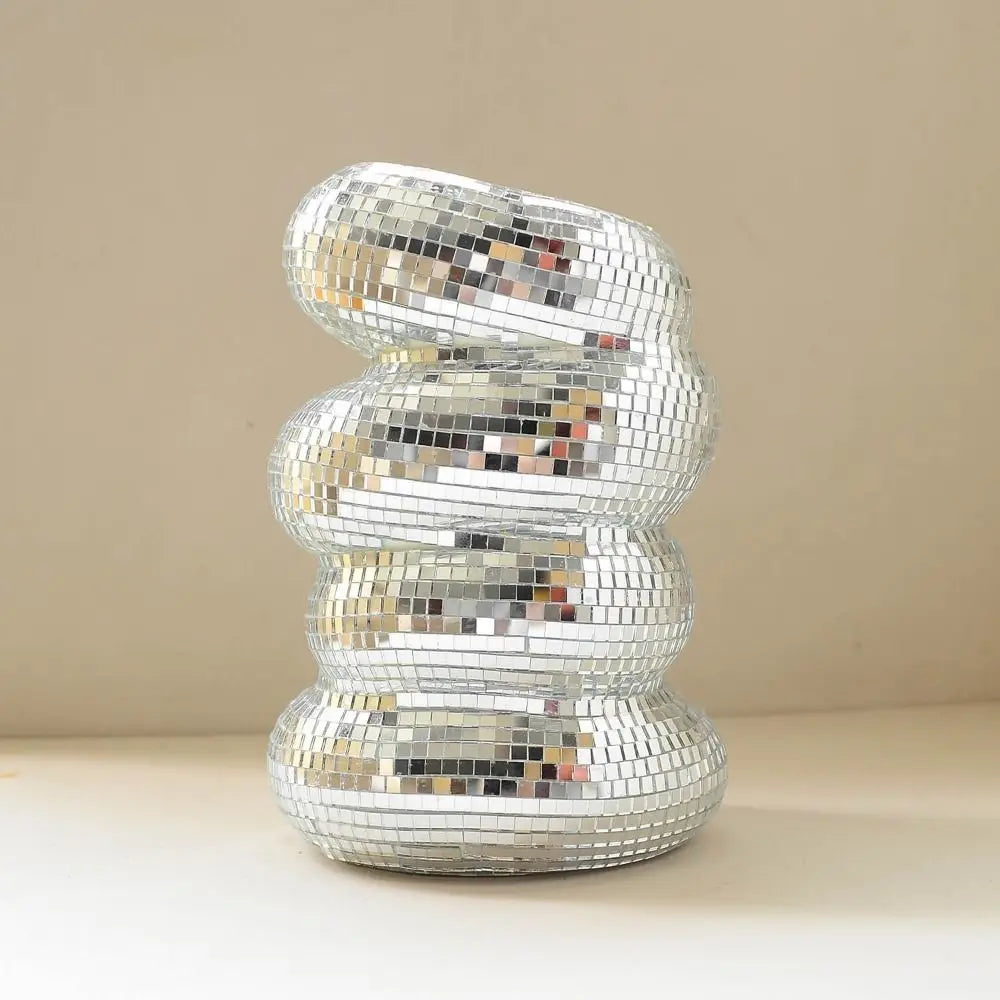 A spiral sculpture made of silver and iridescent mosaic tiles, shaped like a disco ball.