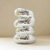 A spiral sculpture made of silver and iridescent mosaic tiles, shaped like a disco ball.