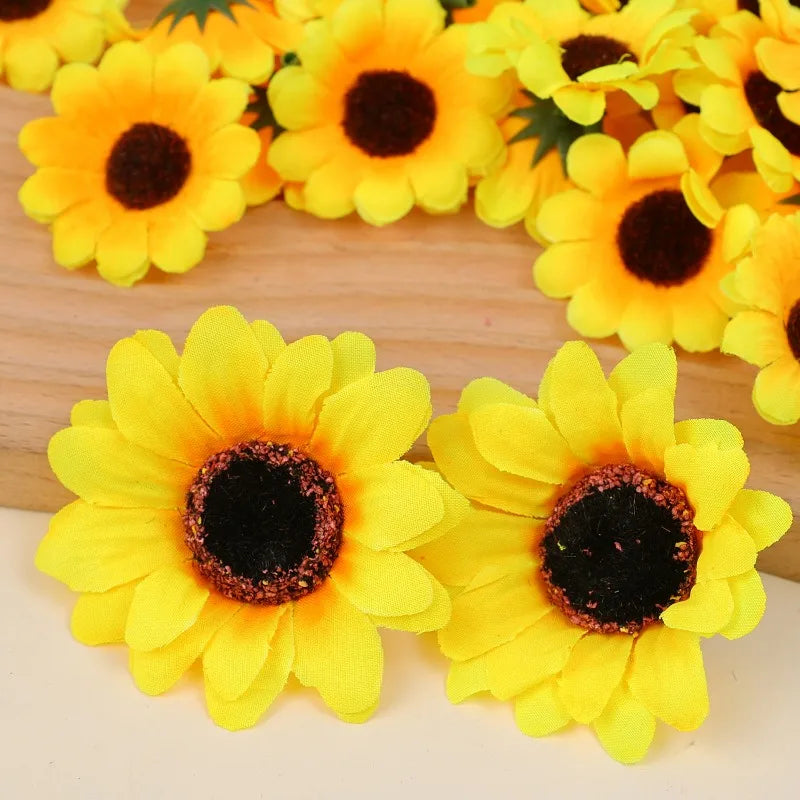A cluster of bright yellow artificial sunflower heads with dark centers arranged on a wooden surface.