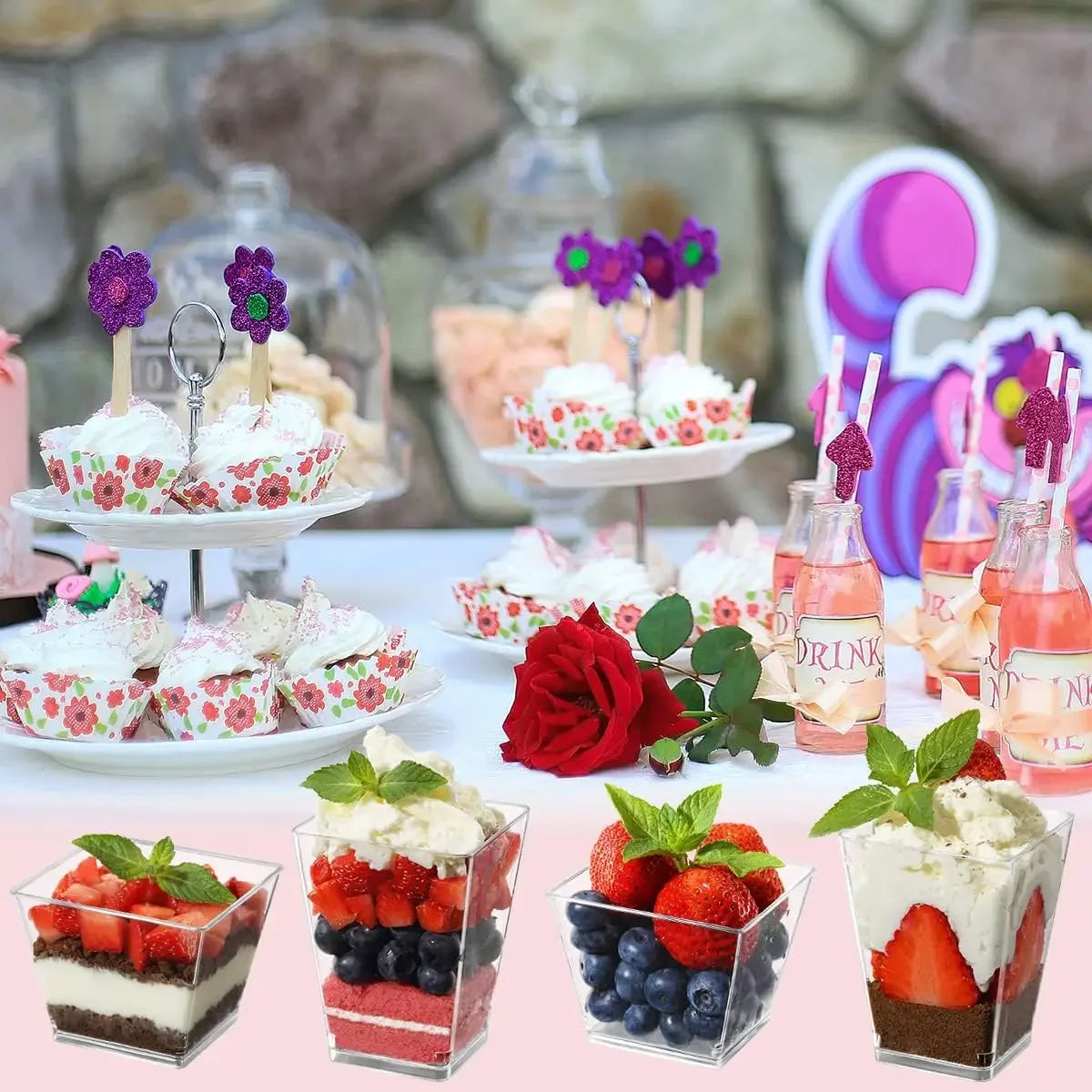 A display of elegant mini dessert cups filled with cream and fruit, arranged on a white platter.