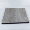 A rectangular piece of gray wood grain laminate or sticker material with a black edge.