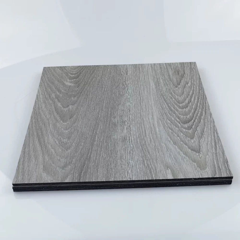 A rectangular piece of gray wood grain laminate or sticker material with a black edge.