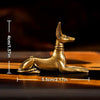 A vintage brass pharaoh hound statue with an Egyptian-inspired design, shown in profile against a dark background.