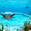 A white, articulated sea monster fidget toy with a wide open mouth and teeth is visible underwater.