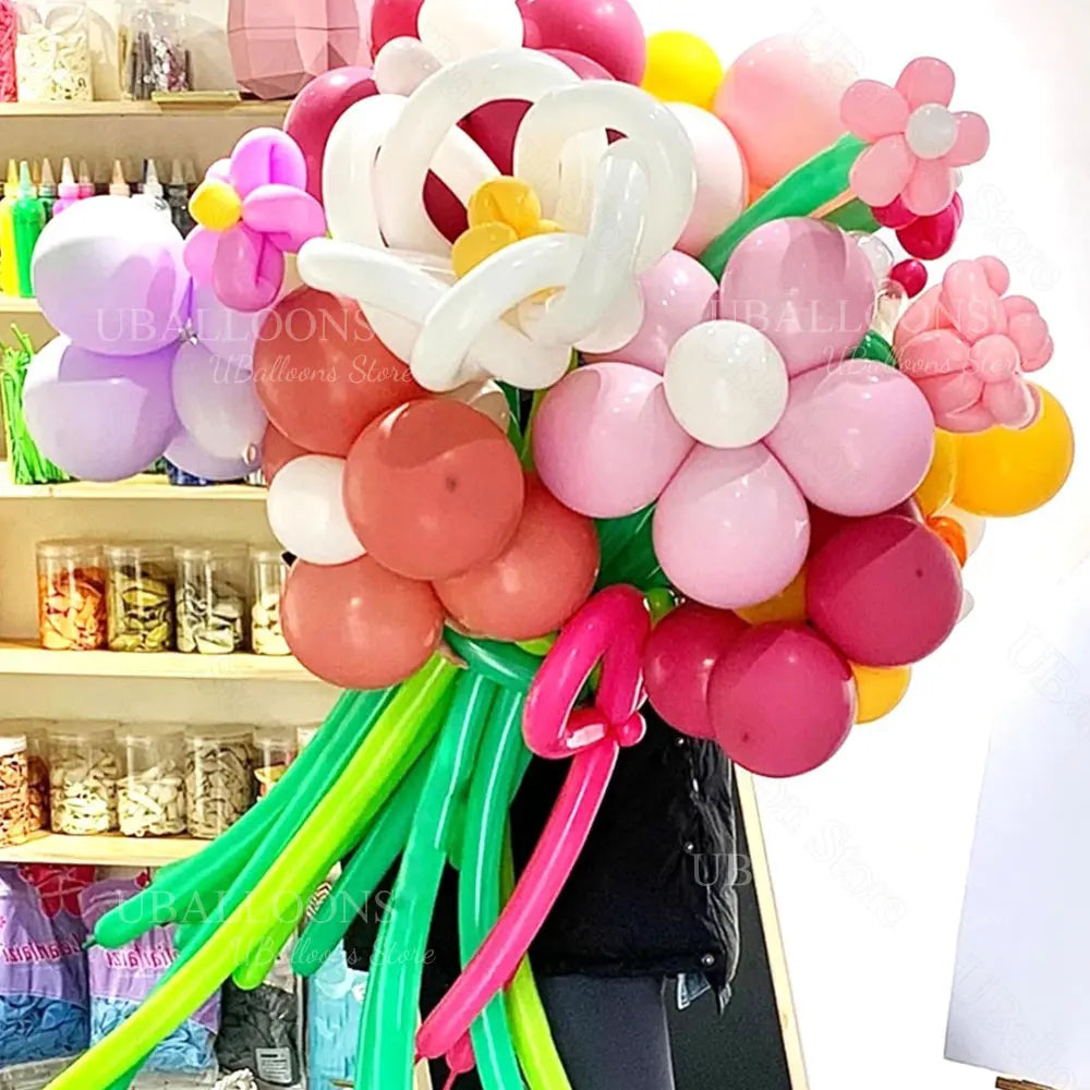 A bouquet of pink, white, and yellow magic twisting balloons for party decorations