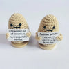 Two handmade knitted plush dolls shaped like potatoes with signs encouraging a positive outlook