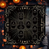 A black altar cloth with white Celtic cross design surrounded by decorative elements and lit candles.