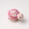 Handmade crocheted turtle plush with pink and purple scales and a smiling face