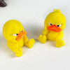A yellow 3D printed statue of an angry duck with orange beak and yellow feet.