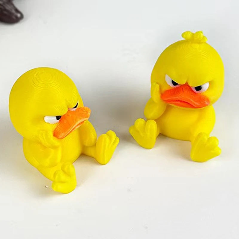 A yellow 3D printed statue of an angry duck with orange beak and yellow feet.