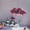 A silver and pink disco glass mirror ornament shaped like clouds is displayed on a white surface.
