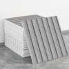 A stack of self-adhesive marble tile stickers in gray and white stripes on a concrete surface.