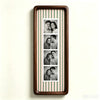 A vertical photo strip frame with a walnut wood border and alternating pale green and pink stripes, displaying six portrait p
