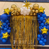 Arche de ballons festive avec des ballons or et bleu et des décorations en étoiles dorées.