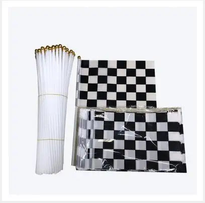 A set of black and white checkered flags and a white pleated fan for a birthday racing car party decoration.