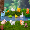 A set of mini animal fairy garden decor featuring rabbits, a pig, a cat, and other small woodland creatures on green moss.