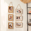 A set of five rustic wooden collage photo frames hanging on a wall, featuring various personal pictures.