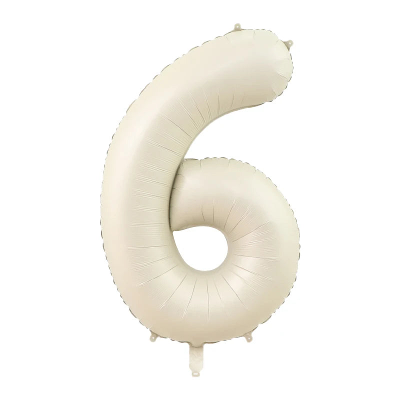 A large, beige foil number balloon shaped like the numeral six.