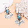 Boucles d'oreilles pendantes en pièce de monnaie turquoise bohème argentées avec des détails de filigrane complexes