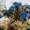 A bouquet of artificial silk blue and white roses with green foliage for home decor