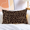 A brown and black leopard print decorative pillow cover resting on white bedding.