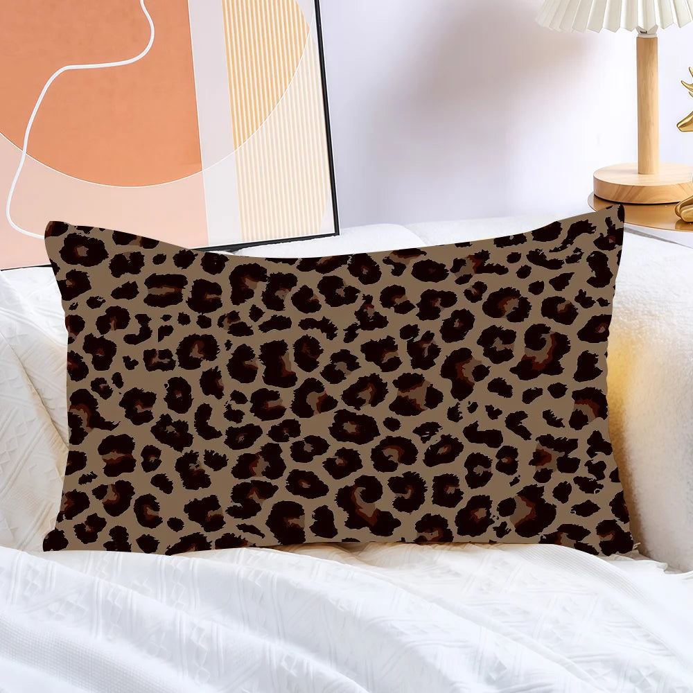 A brown and black leopard print decorative pillow cover resting on white bedding.