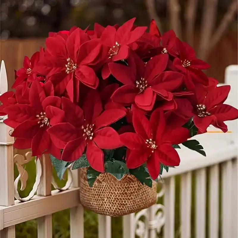 A bouquet of vibrant red artificial poinsettia flowers displayed in a woven pot on a white railing.