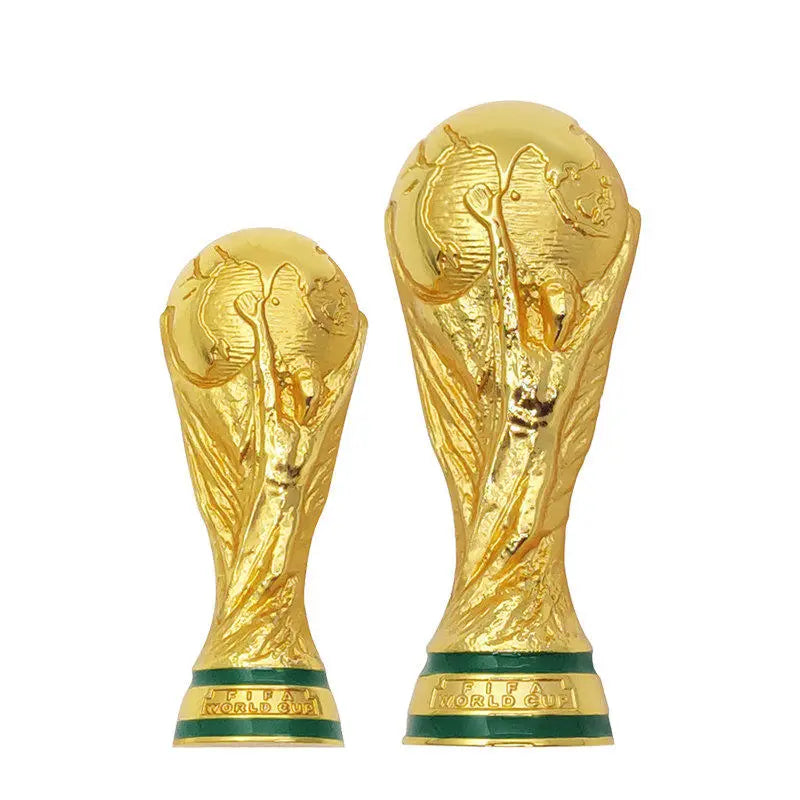 A gold-colored replica of the FIFA World Cup trophy, displayed as a fridge magnet.