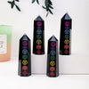A set of black obsidian crystal towers with colorful gemstone accents displayed on a white surface.