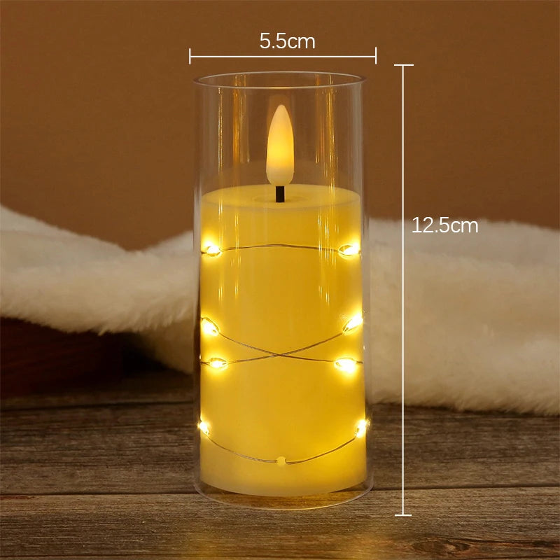 A tall glass candle holder filled with yellow wax and featuring a glowing flame and string lights.