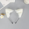 A white plush fox ears headband with black nose wires is displayed on a gray surface.