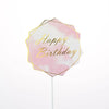 A pink watercolor hexagon flag with gold text that reads Happy Birthday