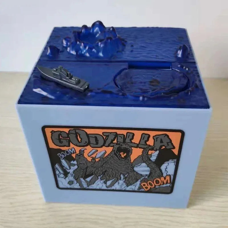 A blue resin piggy bank shaped like Godzilla with a dark gray Godzilla figure inside.