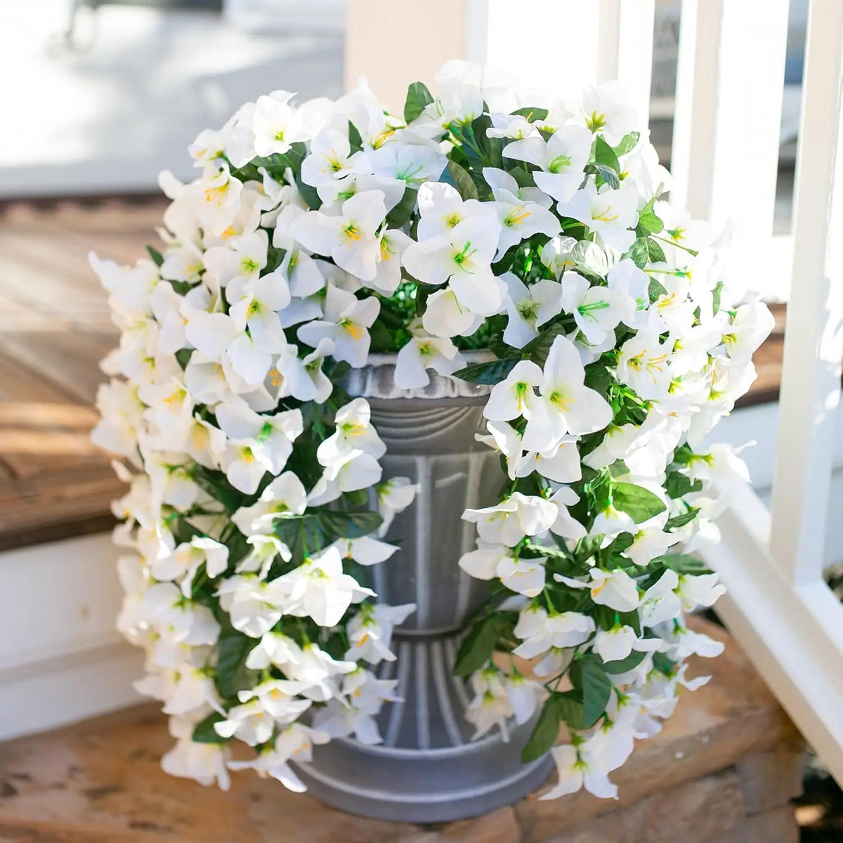 A lush white artificial bougainvillea vine garland displayed in a silver urn for home or wedding decor.