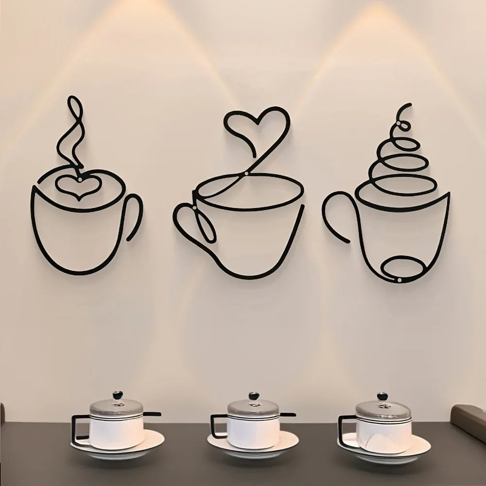 A set of three black iron coffee cup silhouettes mounted on a wall with focused lighting.