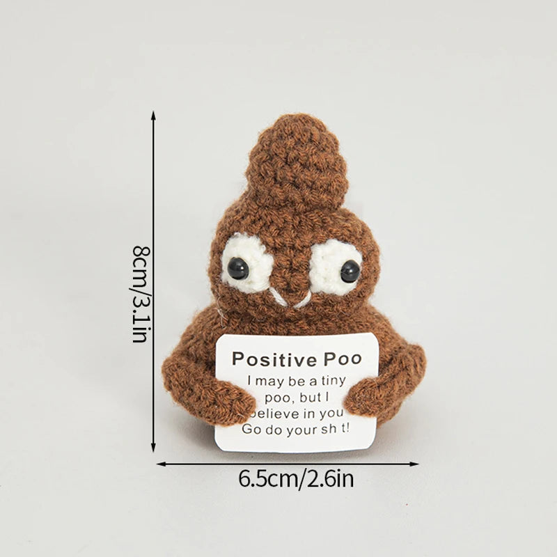 A handmade crochet positive potato doll with a brown textured body and white eyes, featuring an inspirational slogan on the t