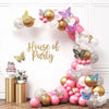 A decorative wall display featuring a gold and pink balloon garland with butterfly accents for a party theme.