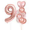 A set of rose gold foil balloons shaped like the number 9 and several round balloons for party decoration
