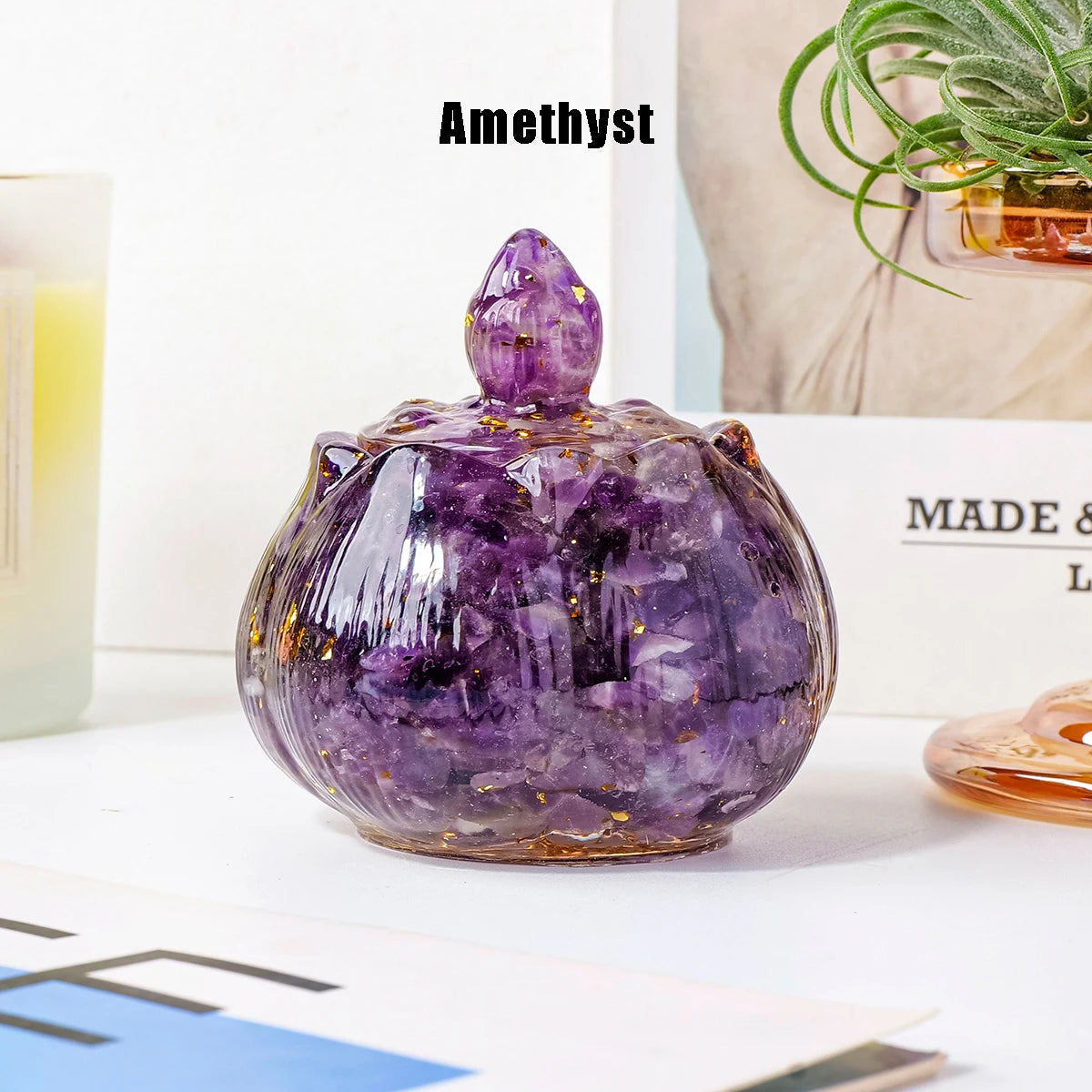 A polished amethyst crystal bowl with a pointed top sits on a white surface.