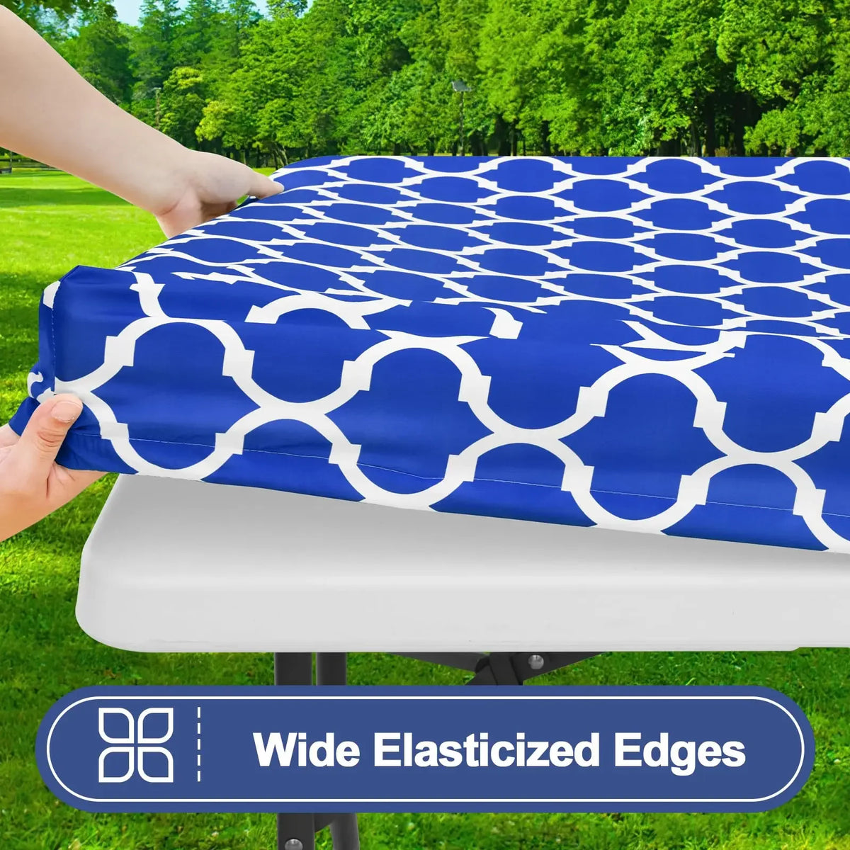 A blue patterned waterproof elastic fitted tablecloth is being placed on a white table.