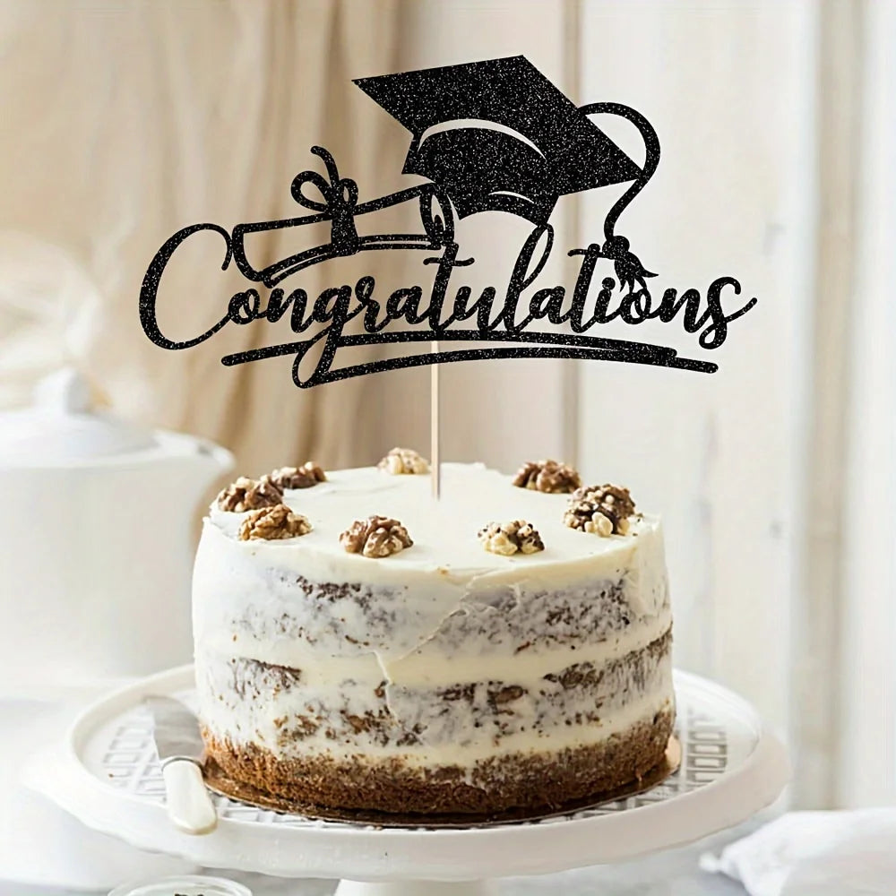 A round white cake decorated with thin layers of frosting and topped with a black graduation cap silhouette and the word cong