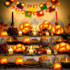 String lights shaped like orange marigolds decorating a festive display with candles and foliage
