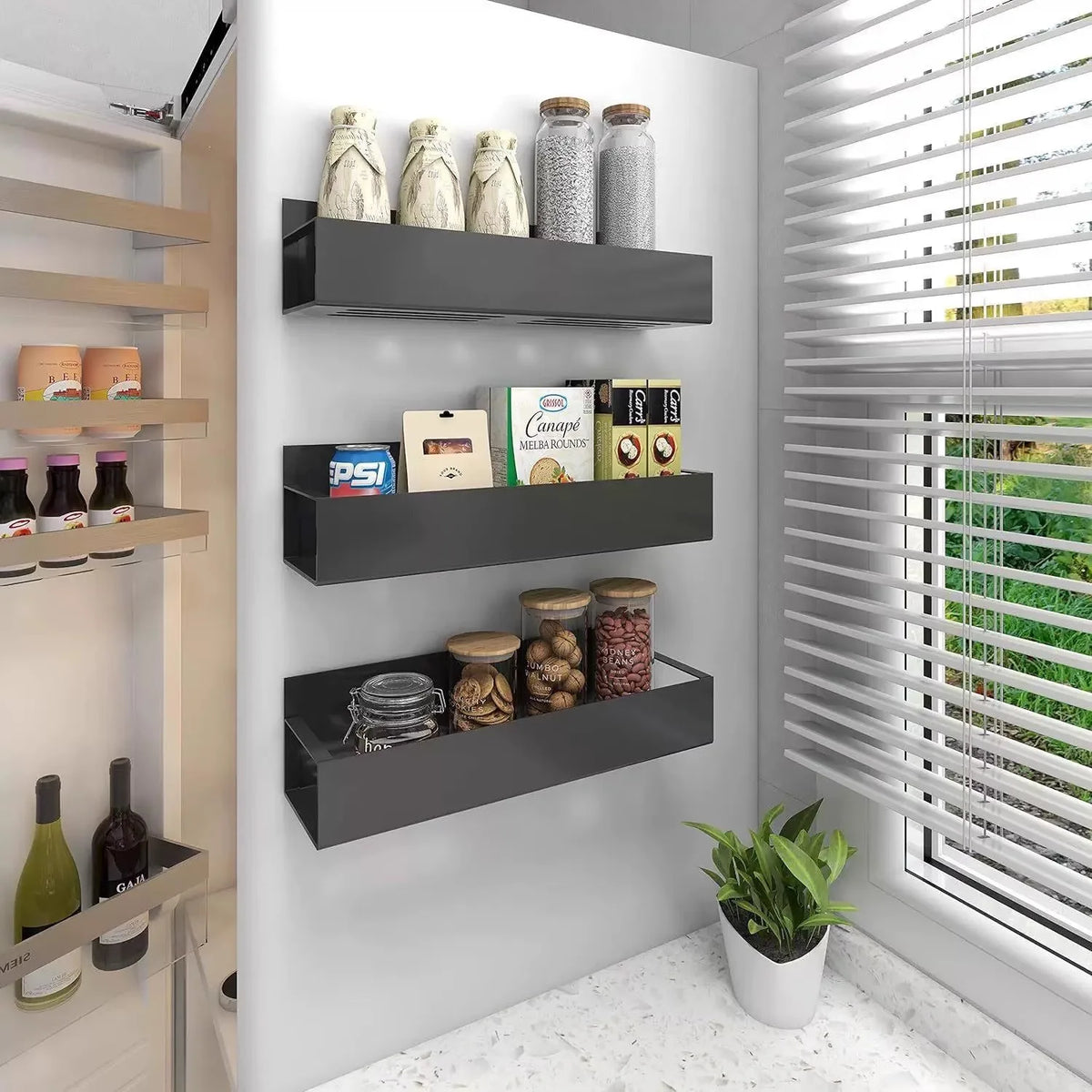 A black magnetic spice rack with glass jars is mounted on a white wall next to a window.