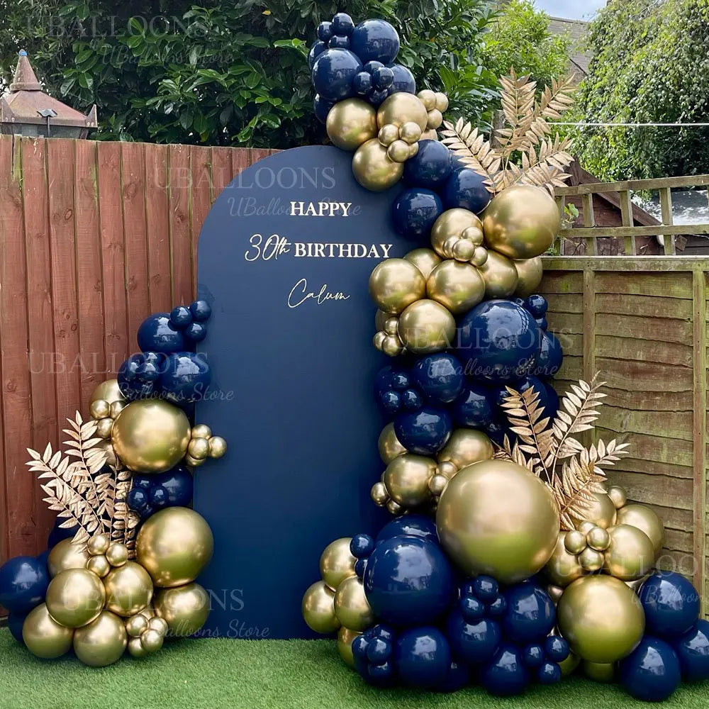 A balloon garland featuring metallic gold and navy blue balloons used for party decoration.