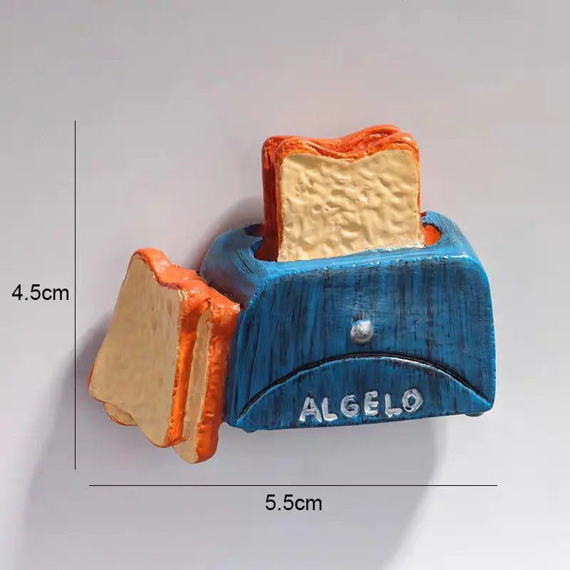 A set of two 3D fruit fridge magnets, a banana and an avocado, featuring orange and yellow tones.