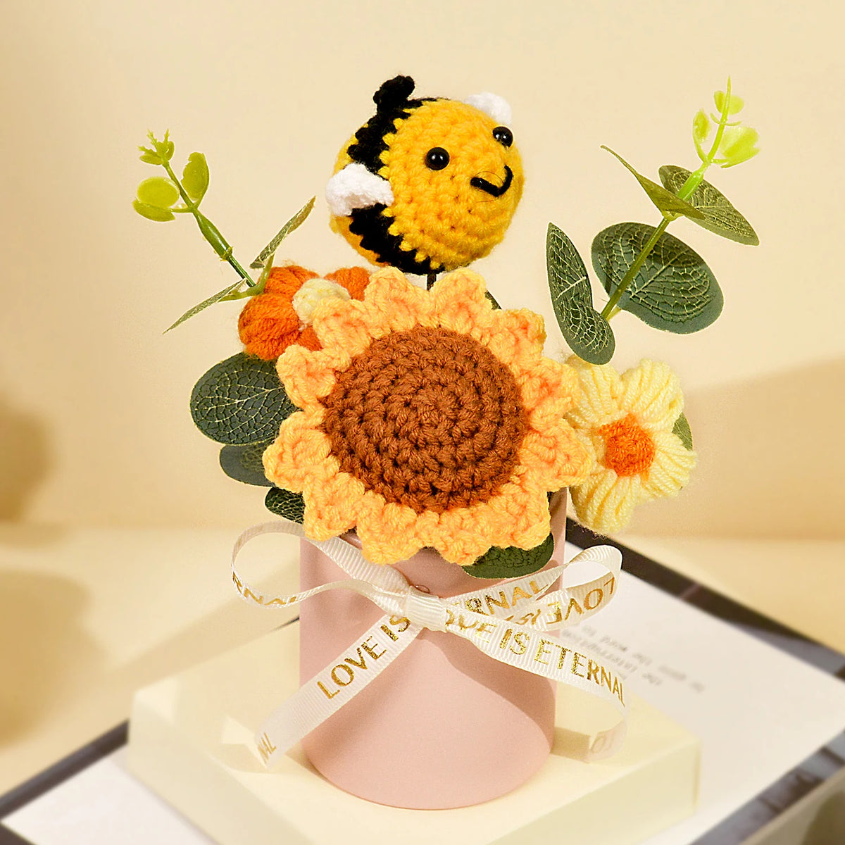 Handmade crochet sunflower bouquet with green leaves presented in a pink gift box