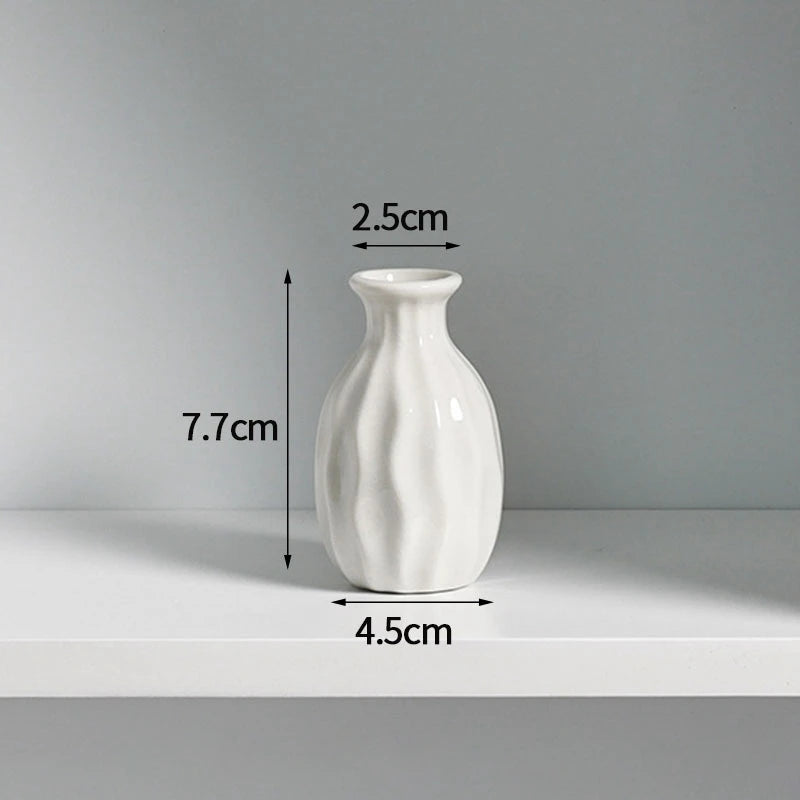A white ceramic mini vase with a textured surface is shown on a shelf.